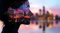 Female profile silhouette with double exposure of illuminated city skyline at sunset, blending urban landscape with human form against purple and orange sky.