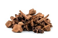 Aromatic star anise pods and cinnamon sticks scattered on white background, natural spices and herbs for cooking and flavoring food, isolated macro shot.