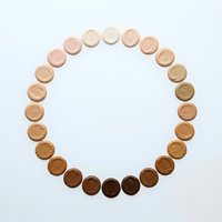 Makeup foundation concealer samples arranged in circle showing diverse skin tone shades from light to dark for cosmetic color matching and beauty products.