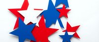 Patriotic red white and blue paper stars scattered on white background for Independence Day celebrations and American holiday decorations.