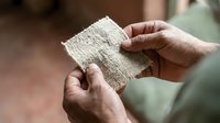 Hands holding natural linen fabric swatch, showcasing textile quality and weave for fashion, interior design, and material selection projects.