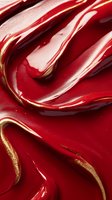 Luxurious red and gold liquid cosmetic texture with smooth swirls and waves creating an elegant abstract pattern for beauty product advertising background.