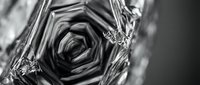 Macro shot of ice crystal formations with intricate geometric patterns and frozen water details in monochrome for winter and nature backgrounds.