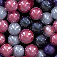 Glossy spheres in pink, purple and silver colors arranged in seamless pattern on black background, creating modern abstract geometric composition.