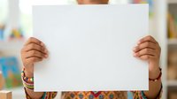 Young child with medium skin tone holding blank white poster board for messaging or advertising purposes in educational setting.