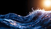 Dynamic blue ocean wave with splashing water droplets against dark background illuminated by golden sunlight, creating dramatic contrast.