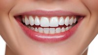 Close up of bright white healthy teeth and pink lips showing natural smile against light skin tone background, dental care and oral hygiene concept.