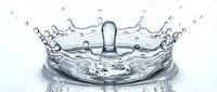 Clear water splash with crown-like formation and droplets captured in high-speed photography showing dynamic liquid motion and crystalline transparency.