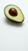 Fresh ripe avocado half with pit on white background isolated for healthy eating and cooking designs.