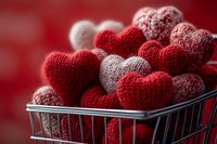 Knitted hearts in shopping cart for Valentine's Day love concept with red and white wool yarn decorations for romantic holiday celebration and gift ideas.