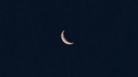 Crescent moon glowing against dark night sky background, minimalist astronomical composition for celestial and space designs.