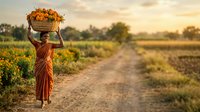 Woman farmer carrying basket of harvested vegetables on head walking along rural dirt road through agricultural field at sunset.