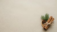 Cinnamon sticks tied with twine alongside fresh evergreen sprigs on neutral beige background, suitable for holiday, wellness, and seasonal design projects.