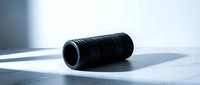 Black foam roller for muscle recovery and fitness training on white surface with dramatic lighting and shadows for sports equipment photography.