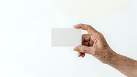 Senior male hand holding blank white card against neutral background for business messaging and promotional content.