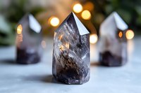 Smoky quartz crystal points with natural inclusions on light background, bokeh lights creating mystical atmosphere for spiritual and wellness concepts.