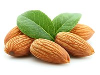 Fresh raw almonds with green leaves isolated on white background, macro shot showing detailed texture of nuts and leaf veins. Natural healthy snack concept.