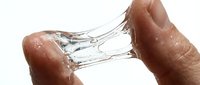 Hands holding transparent glass with water splashing against white background, isolated design element for commercial use.