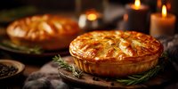 Homemade savory pie with golden flaky crust on wooden board, garnished with rosemary sprigs, candlelit dinner atmosphere.