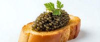 Gourmet caviar served on toasted bread slice with fresh parsley garnish, isolated on white background for culinary and food styling projects.
