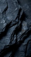Dark charcoal coal pieces with rough textured surface and natural cracks. Raw mineral fuel energy resource for industrial mining and power generation.
