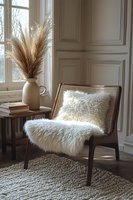 Cozy reading corner with wicker chair, fluffy white throw, pampas grass in ceramic vase and natural light streaming through window for home decor inspiration.