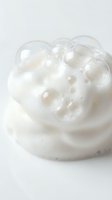 White foam bubbles on cream surface creating abstract texture for skincare and beauty product backgrounds.