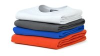 Stack of neatly folded cotton t-shirts in white, gray, blue and red colors isolated on white background. Ready for apparel and clothing design projects.