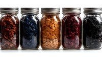 Glass mason jars filled with colorful dried fruits and berries arranged in row showing variety of natural preserved foods against white background.