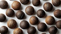 Fresh whole brown coconuts arranged in rows on white background, natural organic tropical fruits isolated for food and cosmetic design projects.