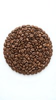 Roasted coffee beans arranged in circular pattern on white background, isolated for cafe branding, restaurant menus, and beverage marketing materials.