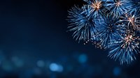 Spectacular blue fireworks exploding against dark night sky with bokeh effect, perfect for celebration backgrounds and holiday designs.