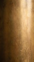 Aged bronze metal surface with scratches and patina showing warm golden tones and weathered texture for vintage industrial design backgrounds.