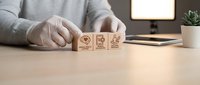 Professional arranging wooden blocks with customer service icons on modern office desk for business strategy and client satisfaction concepts.