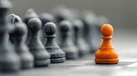 Orange chess pawn standing out from row of black pawns, symbolizing uniqueness, leadership, and strategic differentiation in business competition.
