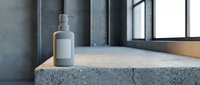 Modern minimalist bathroom with white soap dispenser on concrete countertop near window. Clean industrial design for contemporary home decor and interior styling.