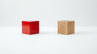 Red and natural wood cube blocks on white background, representing choice, contrast, and decision-making for business and design concepts.