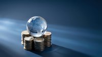 Global economy concept with crystal earth globe resting on stacks of golden coins against blue background for business and finance presentations.