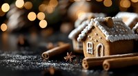 Festive gingerbread house with white icing decorations, cinnamon sticks and star anise on dark background with golden bokeh lights and snow effect.