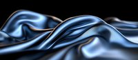 Luxurious dark blue silk fabric with smooth waves and gentle folds creates dramatic light effects against black background, showcasing elegant textile movement.