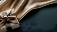 Elegant gift box wrapped in beige satin ribbon against dark background with flowing silk fabric texture creating luxurious holiday or celebration composition.