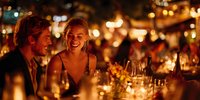 Young couple enjoying romantic dinner at night with warm ambient lighting and wine glasses, creating intimate atmosphere for special occasions.