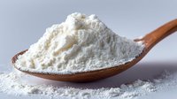 Fine white flour or baking powder on wooden spoon against neutral background, showcasing texture and purity for cooking and baking applications.