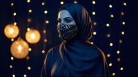 Young Middle Eastern woman wearing ornate face mask and hijab against warm bokeh lights background for fashion and cultural portrait photography.