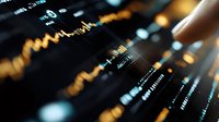 Financial market data displayed on digital screen with orange and blue trading chart patterns showing stock price movements and market analysis indicators.
