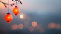 Red paper lanterns glowing against blurred evening cityscape with bokeh lights and setting sun, creating atmospheric Asian festival ambiance.