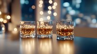 Young adult male, Caucasian appearance, in casual professional setting, pouring whiskey or bourbon into three crystal glasses filled with ice, urban nighttime cityscape with bokeh lights in background, warm golden lighting, luxury lifestyle concept.