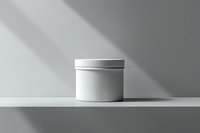 White cosmetic jar on light shelf with dramatic window shadow casting geometric shapes on minimal background, mockup for skincare product packaging.
