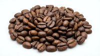 Roasted coffee beans pile isolated on white background for cafe menu design, brewing guides, and beverage marketing materials.