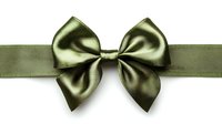 Elegant olive green satin bow and ribbon isolated on white background, ready for gift wrapping, holiday decorations, and design projects.
